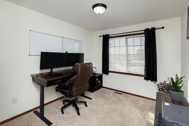 carpeted office space featuring visible vents and baseboards