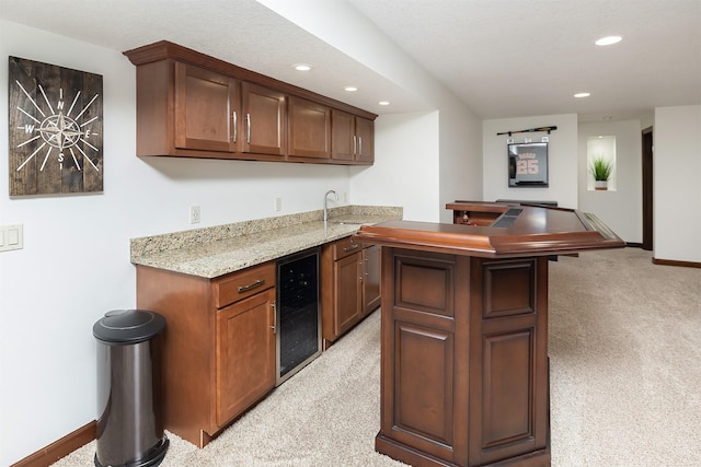 bar with baseboards, beverage cooler, light carpet, recessed lighting, and wet bar