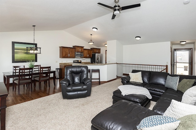 carpeted living area featuring wood finished floors, a ceiling fan, and vaulted ceiling