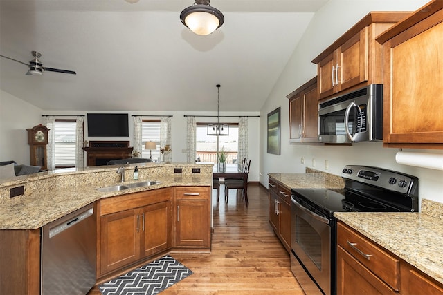 kitchen with a sink, stainless steel appliances, lofted ceiling, and plenty of natural light