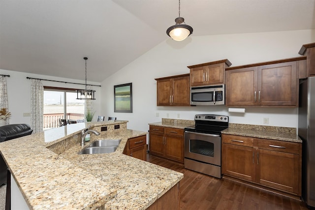 kitchen featuring lofted ceiling, hanging light fixtures, appliances with stainless steel finishes, dark wood-style floors, and a sink