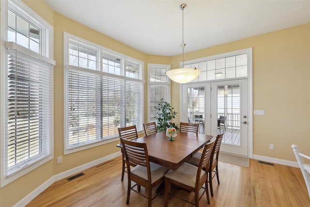 dining space featuring light wood finished floors, visible vents, and baseboards