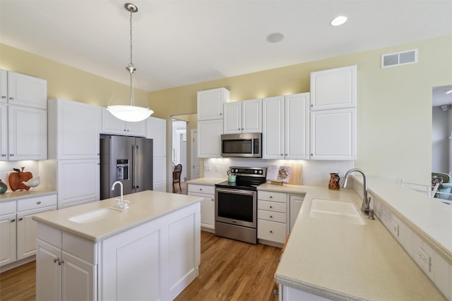 kitchen featuring a sink, visible vents, appliances with stainless steel finishes, and decorative backsplash