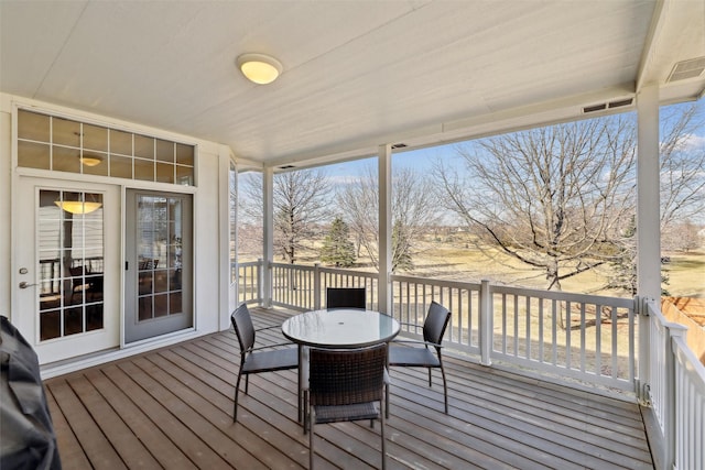 wooden terrace featuring outdoor dining space and visible vents