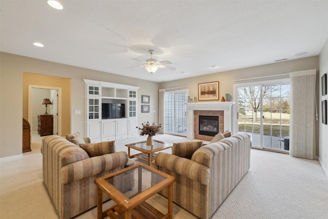 living area with a ceiling fan, visible vents, recessed lighting, a fireplace, and light carpet