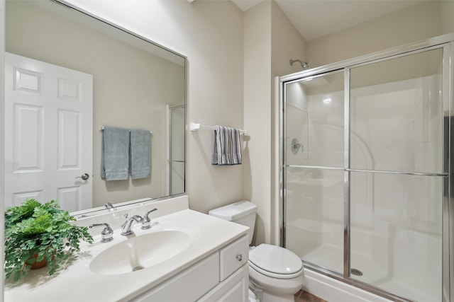 full bathroom with a shower stall, toilet, and vanity