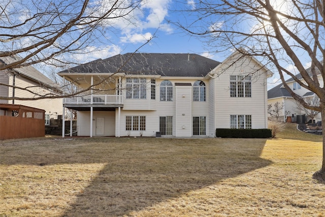 back of house with a lawn, a shingled roof, and fence