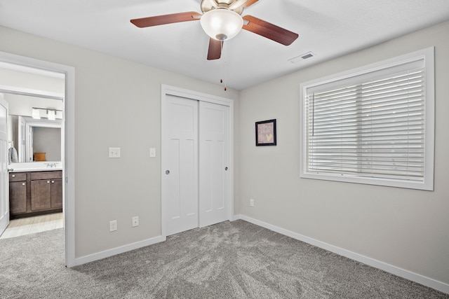 unfurnished bedroom featuring light carpet, visible vents, baseboards, and a closet