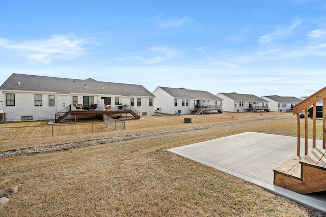 view of yard featuring a deck, fence, stairway, a residential view, and a patio area