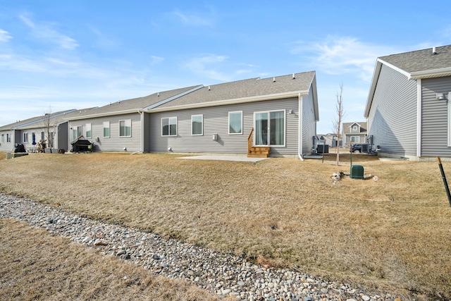 rear view of property with a lawn, entry steps, and a patio