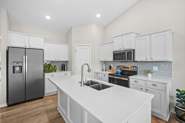 kitchen featuring appliances with stainless steel finishes, white cabinetry, and a sink