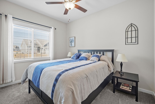 bedroom with a ceiling fan, baseboards, and carpet floors