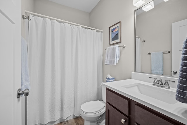 bathroom featuring vanity, a shower with shower curtain, toilet, and wood finished floors