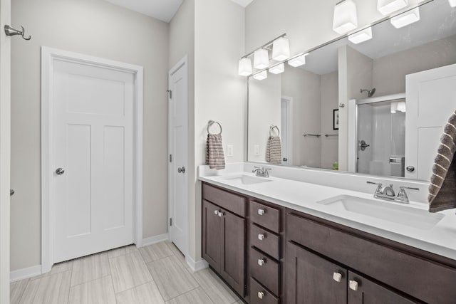 full bathroom with a sink, a stall shower, and double vanity