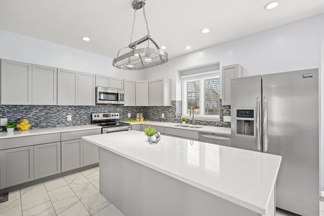 kitchen with gray cabinets, a sink, stainless steel appliances, marble finish floor, and tasteful backsplash