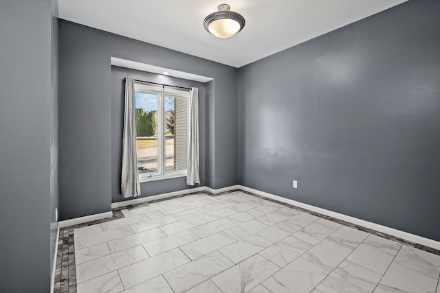 unfurnished room with visible vents, baseboards, and marble finish floor