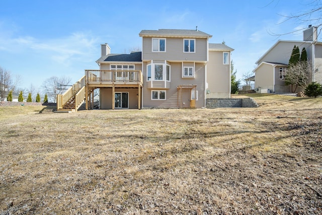 back of property featuring a wooden deck, a chimney, and stairs