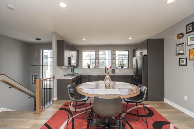 dining room with recessed lighting, light wood-style floors, and baseboards