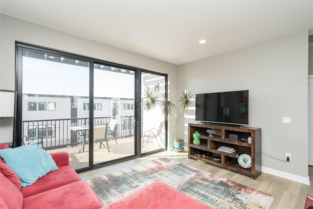 living room featuring recessed lighting, baseboards, and wood finished floors