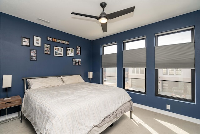 carpeted bedroom featuring a ceiling fan, baseboards, and visible vents