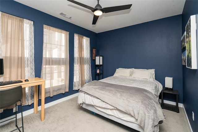 carpeted bedroom with visible vents, a ceiling fan, and baseboards