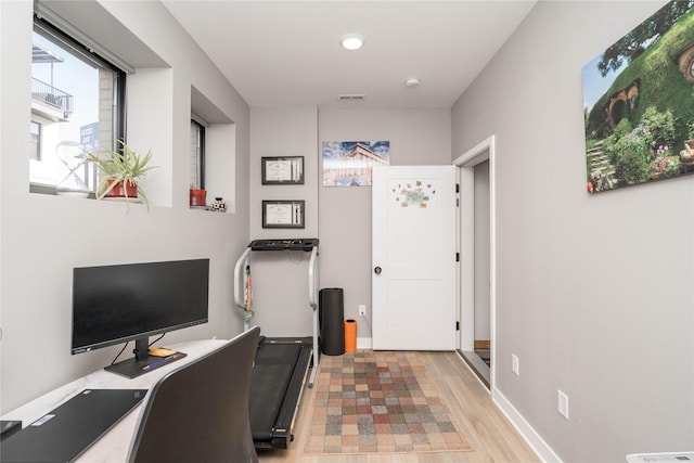 office area with visible vents, baseboards, and wood finished floors