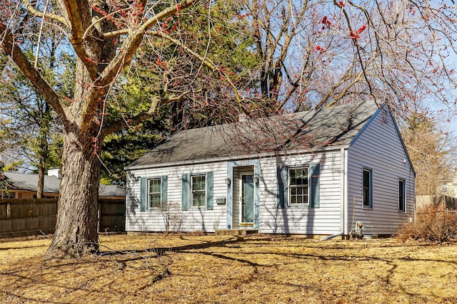 view of front of home featuring roof with shingles and fence