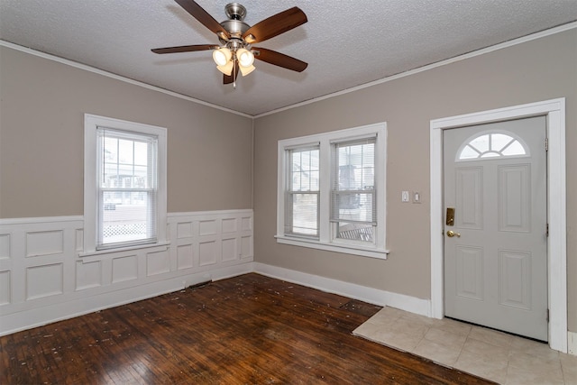 entrance foyer featuring a wealth of natural light, hardwood / wood-style floors, a textured ceiling, and ornamental molding