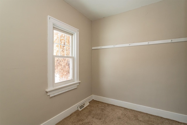 empty room with light carpet, visible vents, and baseboards