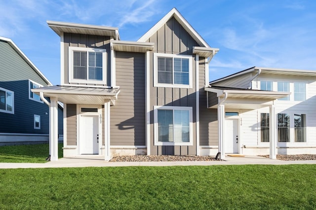 view of front of property featuring a standing seam roof, a front yard, board and batten siding, and metal roof