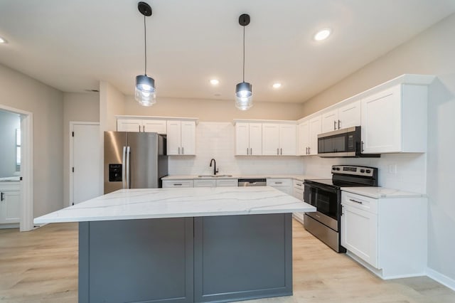 kitchen featuring stainless steel appliances, a kitchen island, white cabinets, and decorative backsplash