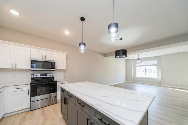 kitchen featuring decorative backsplash, light wood finished floors, white cabinetry, and appliances with stainless steel finishes