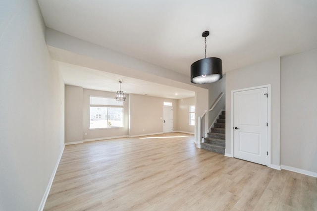 interior space with stairs, light wood-style flooring, and baseboards