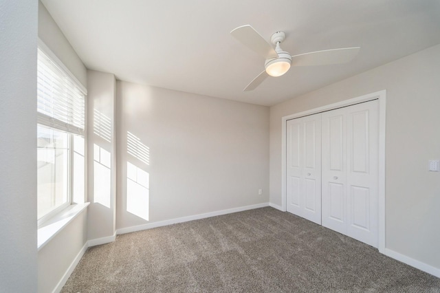 unfurnished bedroom with carpet flooring, baseboards, a closet, and ceiling fan