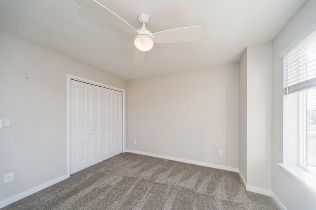 unfurnished bedroom featuring a closet, carpet flooring, a ceiling fan, and baseboards