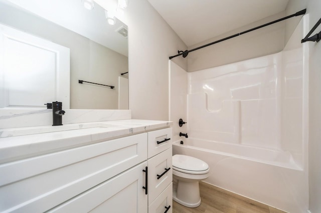 bathroom featuring visible vents, washtub / shower combination, toilet, wood finished floors, and vanity