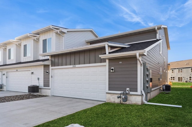 view of property with concrete driveway, a front lawn, a garage, central air condition unit, and board and batten siding