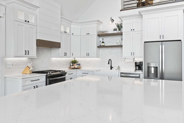 kitchen with open shelves, tasteful backsplash, appliances with stainless steel finishes, and a sink