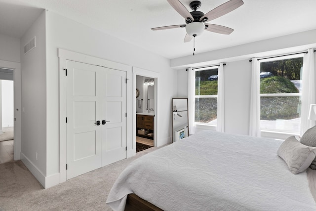 carpeted bedroom with ceiling fan, visible vents, baseboards, and connected bathroom