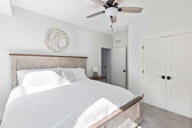 bedroom featuring light colored carpet, visible vents, a closet, and ceiling fan