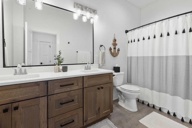 full bathroom with double vanity, tile patterned flooring, toilet, and a sink