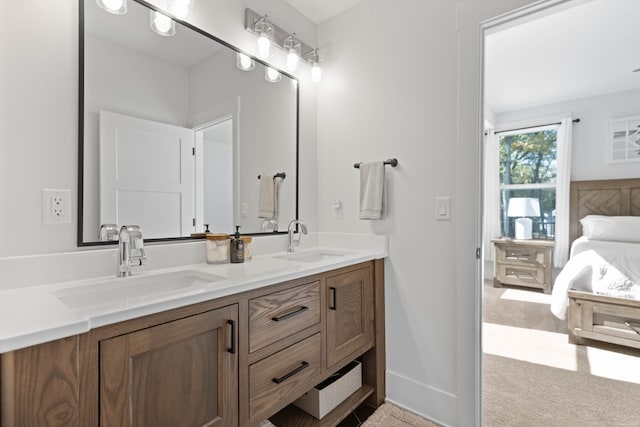 full bath with double vanity, baseboards, and a sink