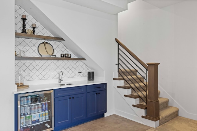 bar with beverage cooler, a sink, backsplash, indoor wet bar, and stairs