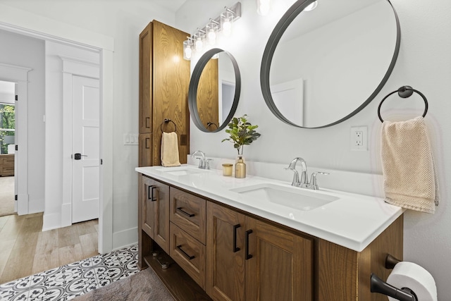 full bathroom featuring double vanity, wood finished floors, and a sink