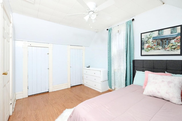 bedroom featuring a ceiling fan, lofted ceiling, and wood finished floors