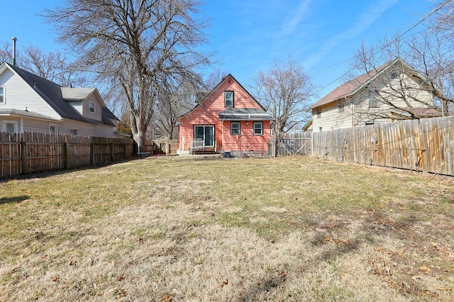 rear view of property featuring a fenced backyard and a yard