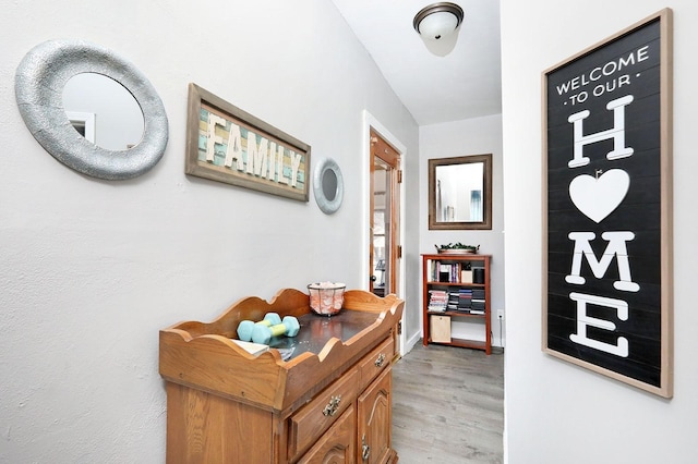 hall with baseboards and light wood-style flooring