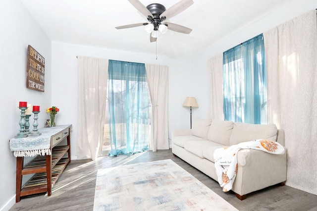 living area with plenty of natural light, a ceiling fan, and wood finished floors