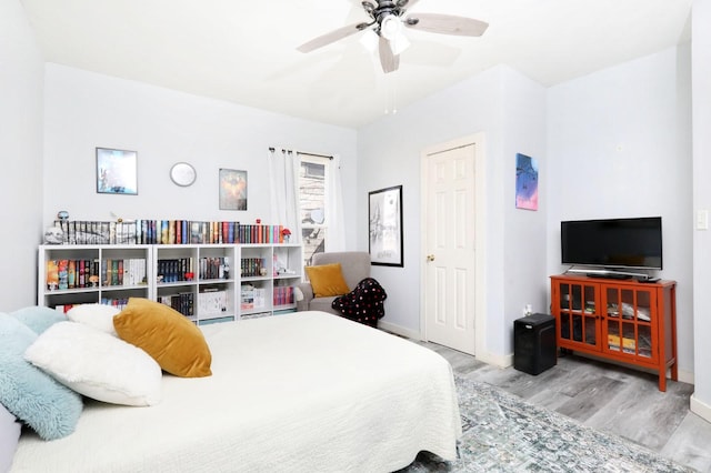 bedroom featuring ceiling fan, baseboards, and wood finished floors