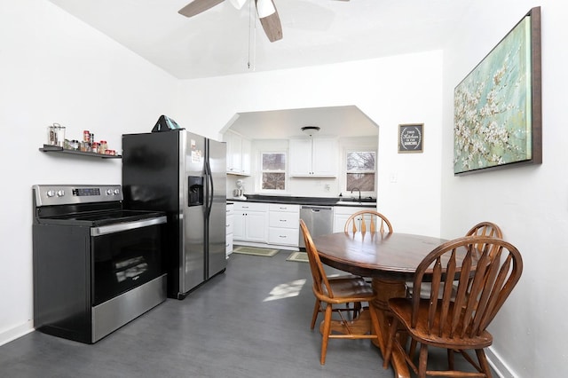 dining room featuring a ceiling fan, baseboards, and arched walkways